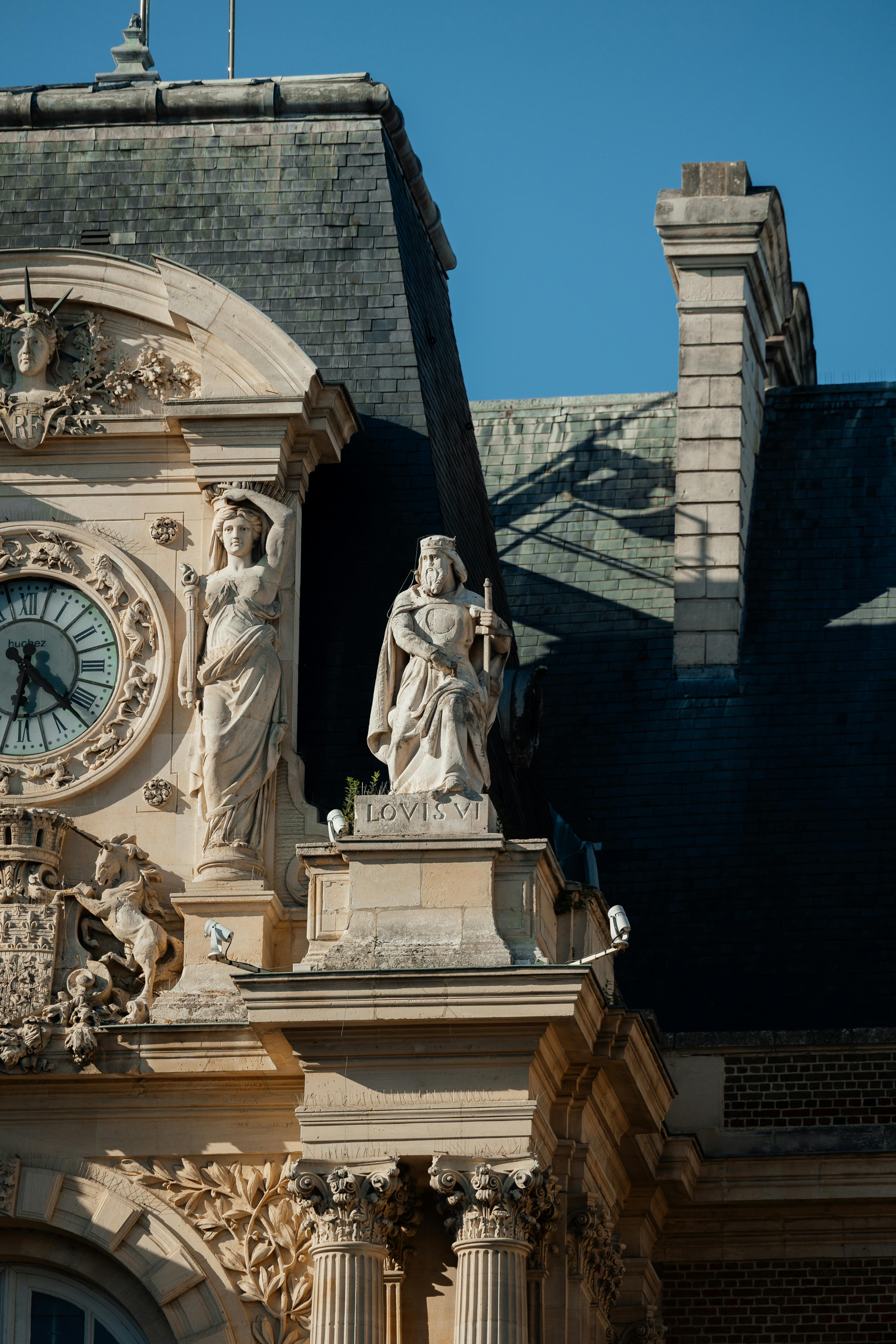 Close up of ornate stone and plaster architecture with classical statues; a glimpse into history and timeless design.
