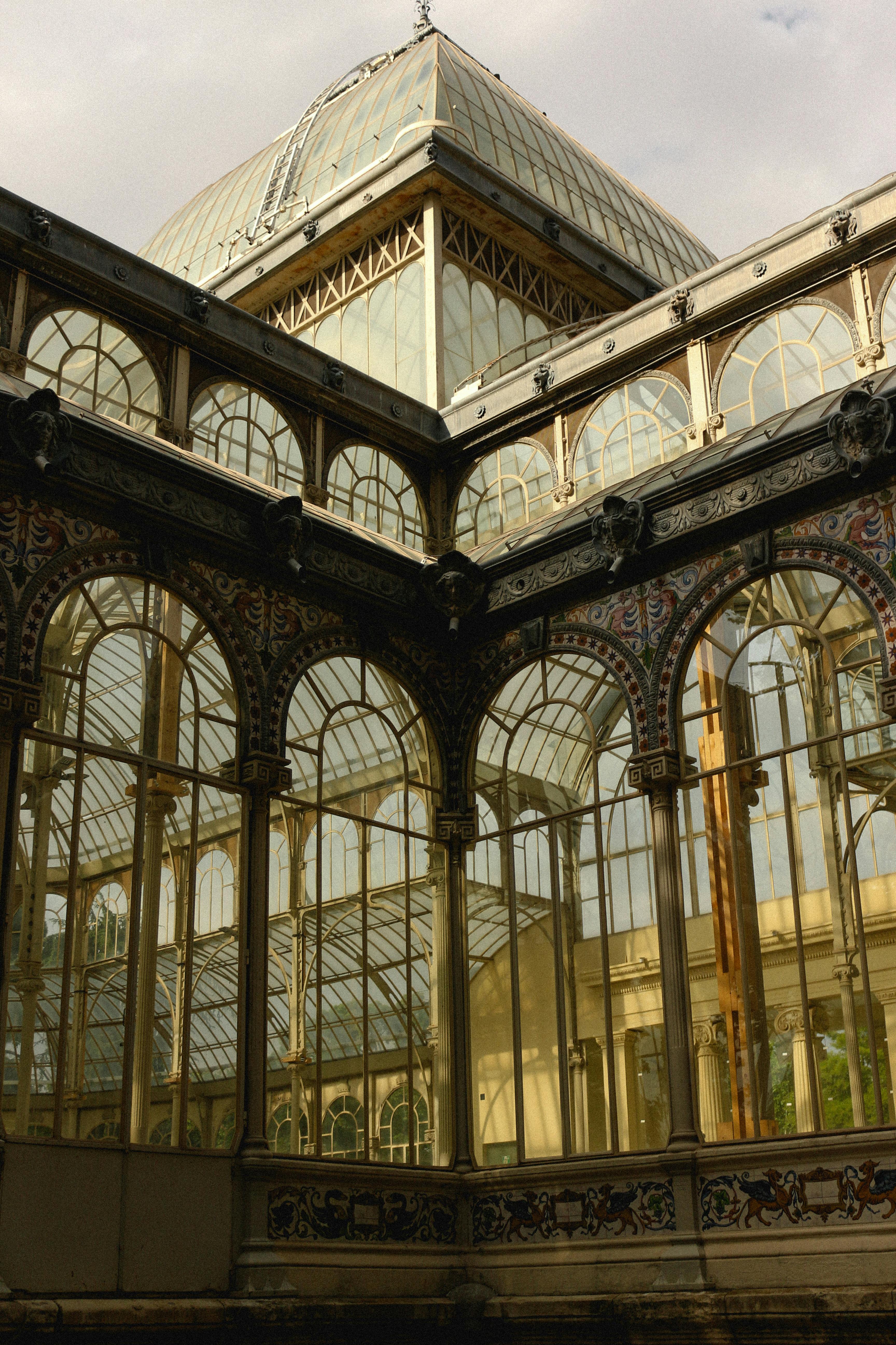 Ornate antique architecture with metal framing, arches, and glass, evoking a sense of history and timeless elegance.
