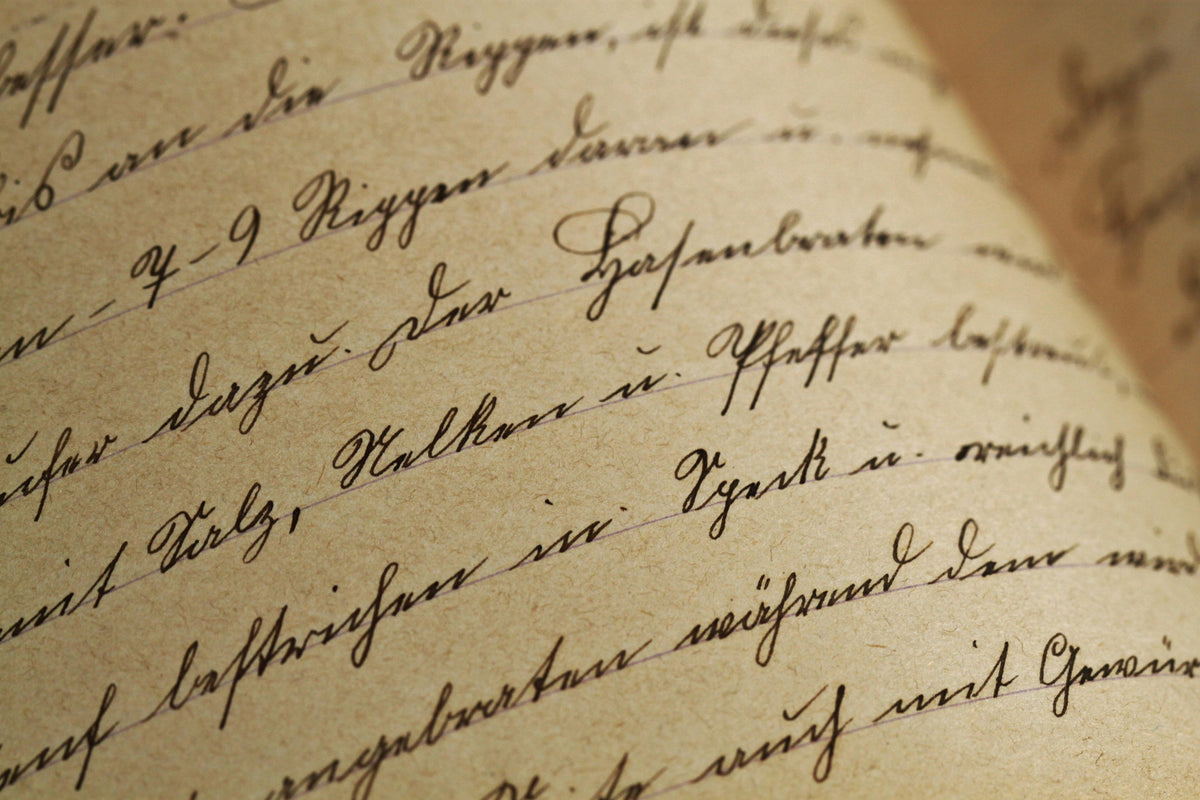 Close-up of handwritten antique script in German, on tan, lined paper, possibly a recipe. Words include "Riggen", "Salz", "Nelken", "Gewürz." Dark ink on aged paper.